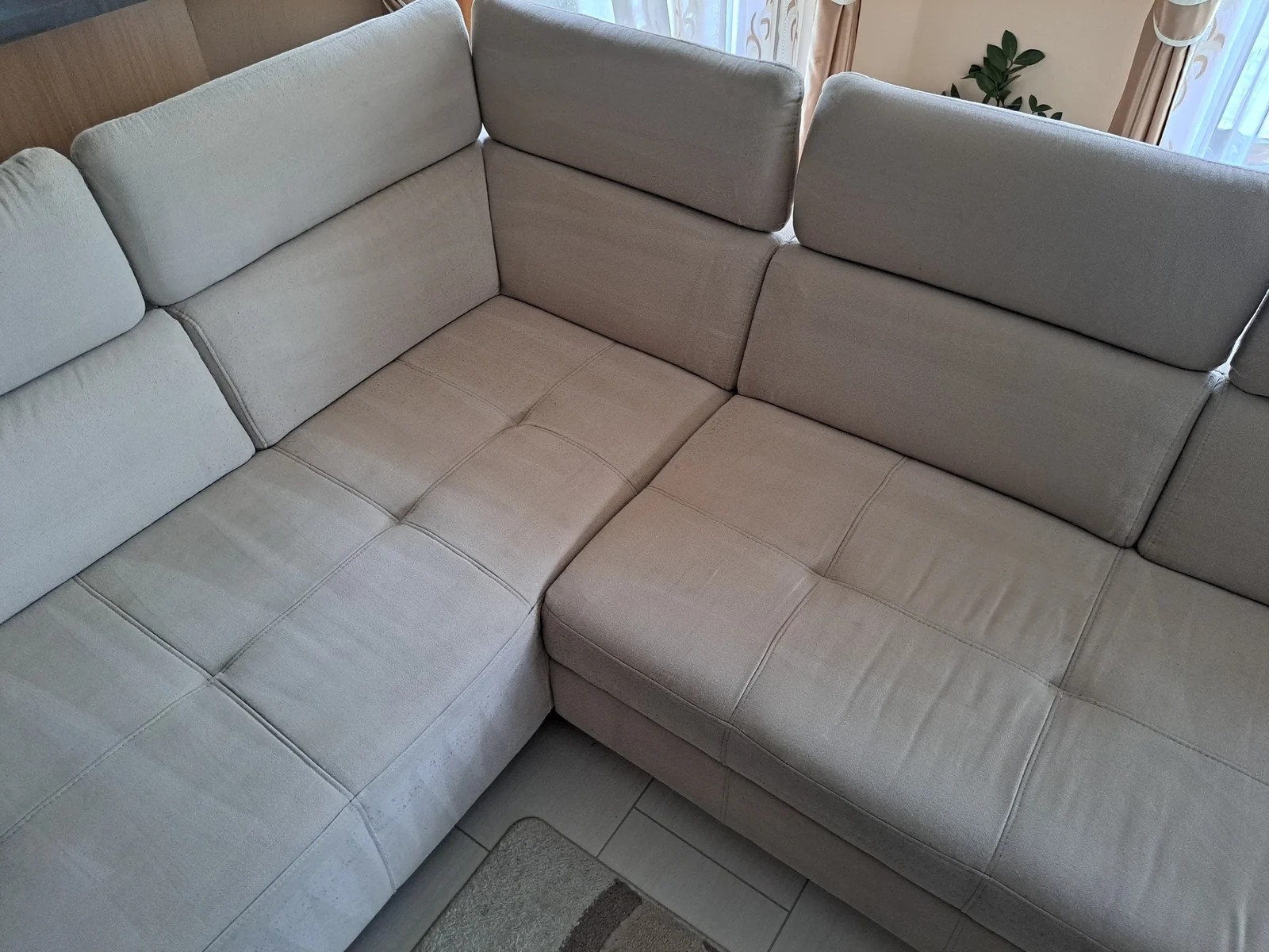 The same light grey corner sofa after cleaning, photographed from a different angle